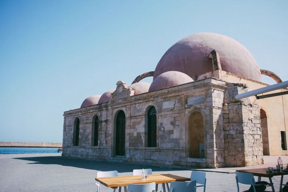 View of a historic Ottoman mosque with domed architecture by the sea.