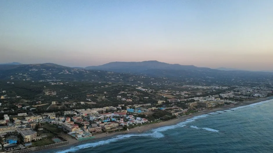 A breathtaking aerial view of Adelianos Kampos, Greece with coastal and mountainous landscapes.