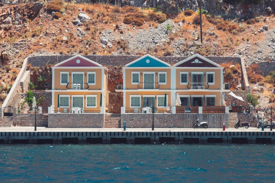 Charming seaside houses with vibrant facades on the island of Ano Symi, Greece.