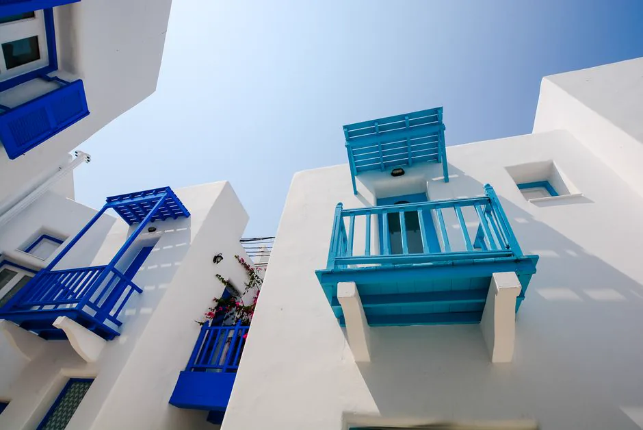 White buildings with vibrant blue balconies under a clear sky, perfect for architectural themes.
